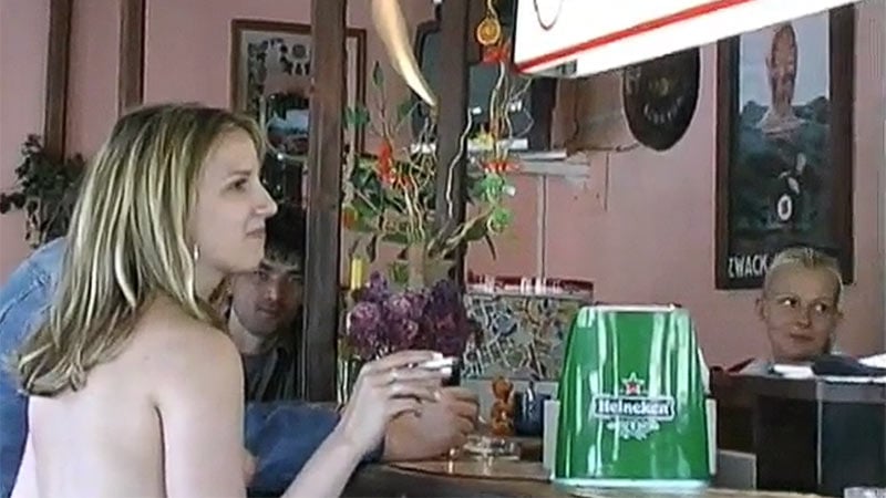 Beautiful naked blonde attracts a lot of attention getting a smoke and ice cream at a bar